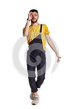 Full-length portrait of a funny guy dancing in studio isolated on white background.