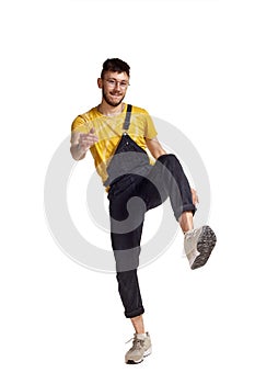 Full-length portrait of a funny guy dancing in studio isolated on white background.