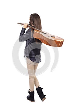 Full length portrait of girl with a guitar on her shoulder, bac