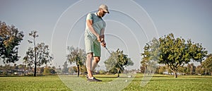 full length portrait of golfer in cap with golf club, sport