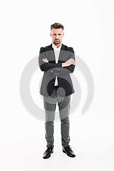 Full-length portrait of handsome businessman in suit posing on c