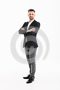 Full-length portrait of handsome businessman in suit posing on c