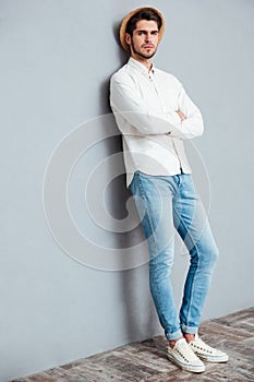 Full length portrait of handsome man standing with arms folded