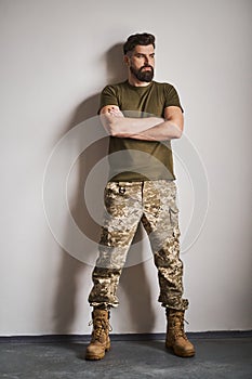 Full length portrait of a handsome and strong bearded soldier
