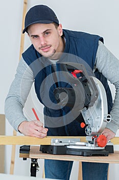 Full length portrait handsome young carpenter indoors