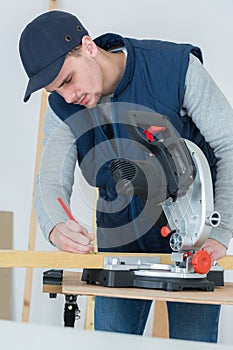 Full length portrait handsome young carpenter indoors