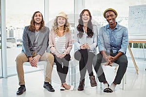 Full length portrait of happy business people sitting on chair