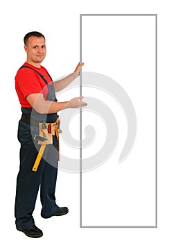 Full length portrait of an happy caucasian construction worker pointing something on an blank billboard. Smiling handsome plumber.