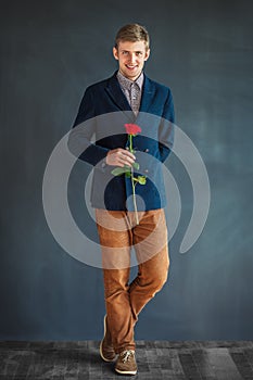 Full length portrait of happy handsome man with red rose