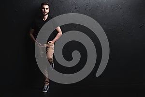 Full length portrait of happy handsome young man on black background.