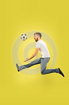 Full length portrait of happy jumping man on yellow background