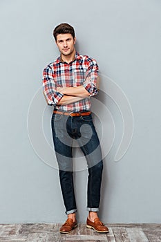 Full length portrait of a happy man with arms folded