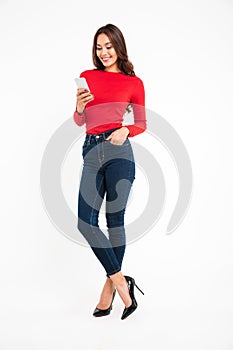 Full length portrait of a happy satisfied asian woman texting