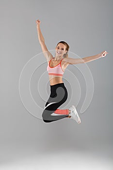 Full length portrait of a happy smiling sportsgirl celebrating