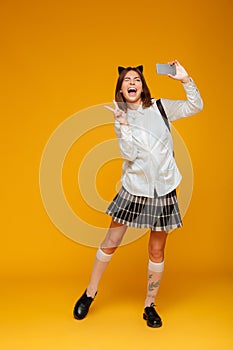 Full length portrait of a happy teenage schoolgirl in uniform