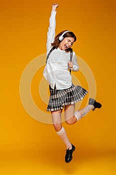 Full length portrait of a happy teenage schoolgirl in uniform