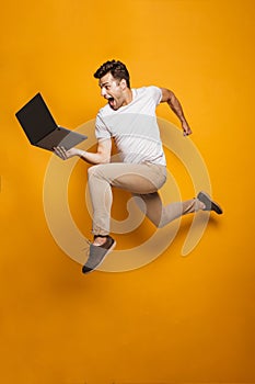 Full length portrait of a happy young man jumping