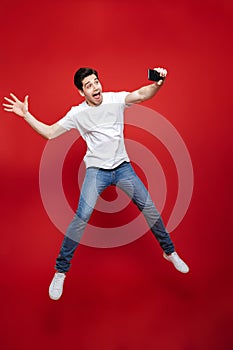 Full length portrait of a happy young man in white t-shirt