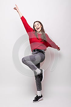 Full length portrait of happy young woman celebrating success  over white background