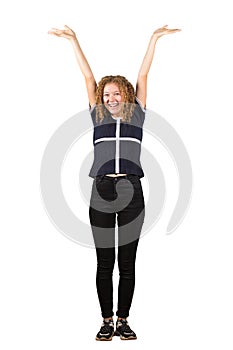 Full length portrait of a joyful adolescent girl, curly hair, raising hands up. Celebrate success like a winner, freedom concept