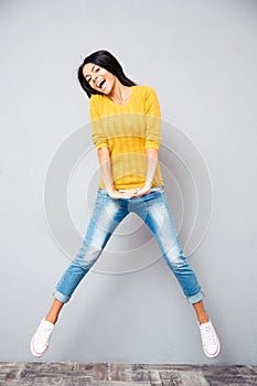 Full length portrait of a laughing woman jumping