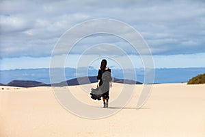 Full length portrait of lonely woman walks away in desert on Can