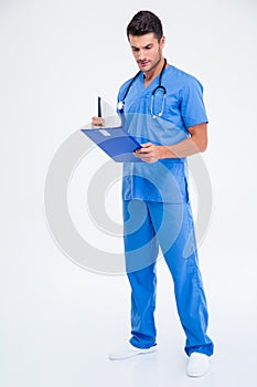 Full length portrait of a male doctor reading clipboard