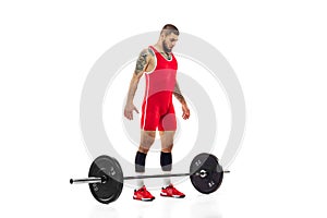 Full length portrait of man in red sportswear exercising with a weight isolated on white background. Sport