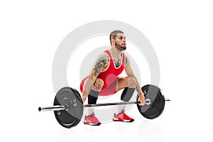 Full length portrait of man in red sportswear exercising with a weight isolated on white background. Sport