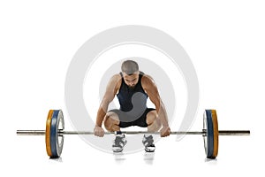 Full length portrait of a man in sportswear exercising with a weight isolated on white background