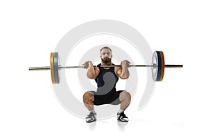 Full length portrait of a man in sportswear exercising with a weight isolated on white background