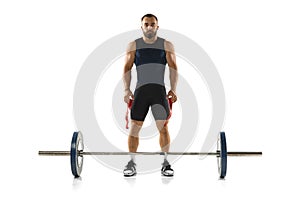 Full length portrait of a man in sportswear exercising with a weight isolated on white background