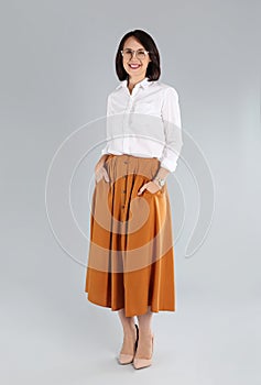 Full length portrait of mature businesswoman on light grey background