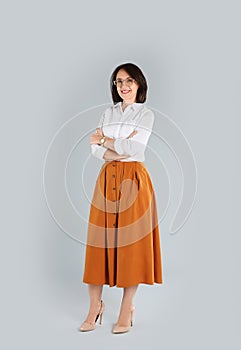 Full length portrait of mature businesswoman on light grey background
