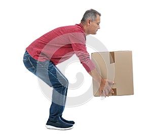 Full length portrait of mature man lifting carton box
