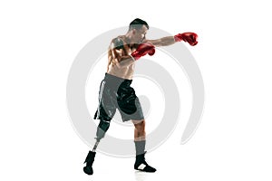 Full length portrait of muscular sportsman with prosthetic leg, copy space. Male boxer in red gloves.