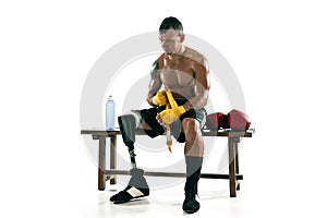 Full length portrait of muscular sportsman with prosthetic leg, copy space. Male boxer in red gloves.