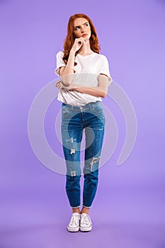Full length portrait of a pensive young girl standing