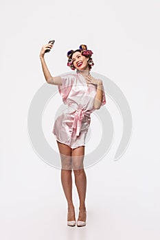 Full length portrait of a pretty housewife with curlers