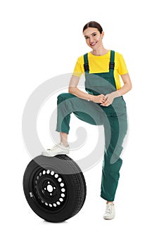 Full length portrait of professional auto mechanic with wheel on white background