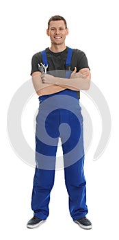 Full length portrait of professional auto mechanic with wrenches on background