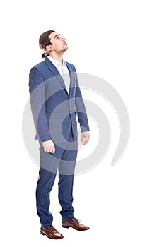 Full length portrait of reflective businessman looking up curious isolated on white background