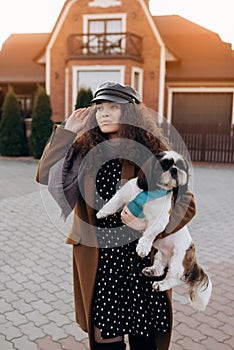 Stunning curly girl in dress posing with shi-tzu.