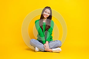 Full length portrait of satisfied glad young person sit floor crossed legs  on yellow color background