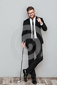Full length portrait of a smiling bearded businessman in suit