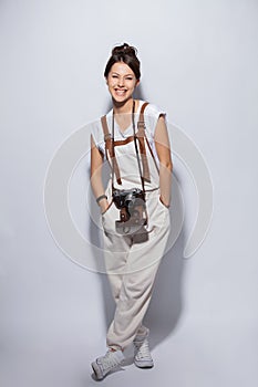 Full length portrait of a smiling casual woman standing on white background and looking at camera.