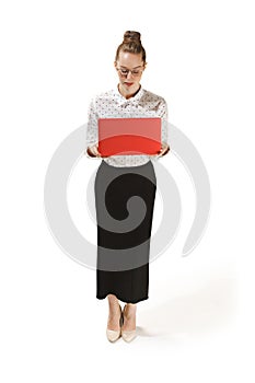 Full length portrait of a smiling female teacher holding a laptop isolated against white background