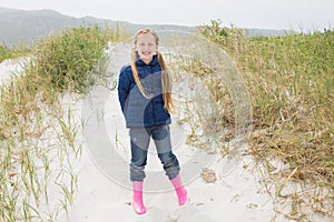 Full length portrait of a smiling girl at beach