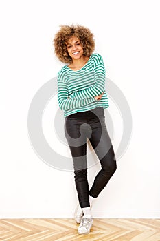Full length smiling young african american woman standing against white wall