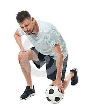 Full length portrait of soccer player with ball having knee problems
